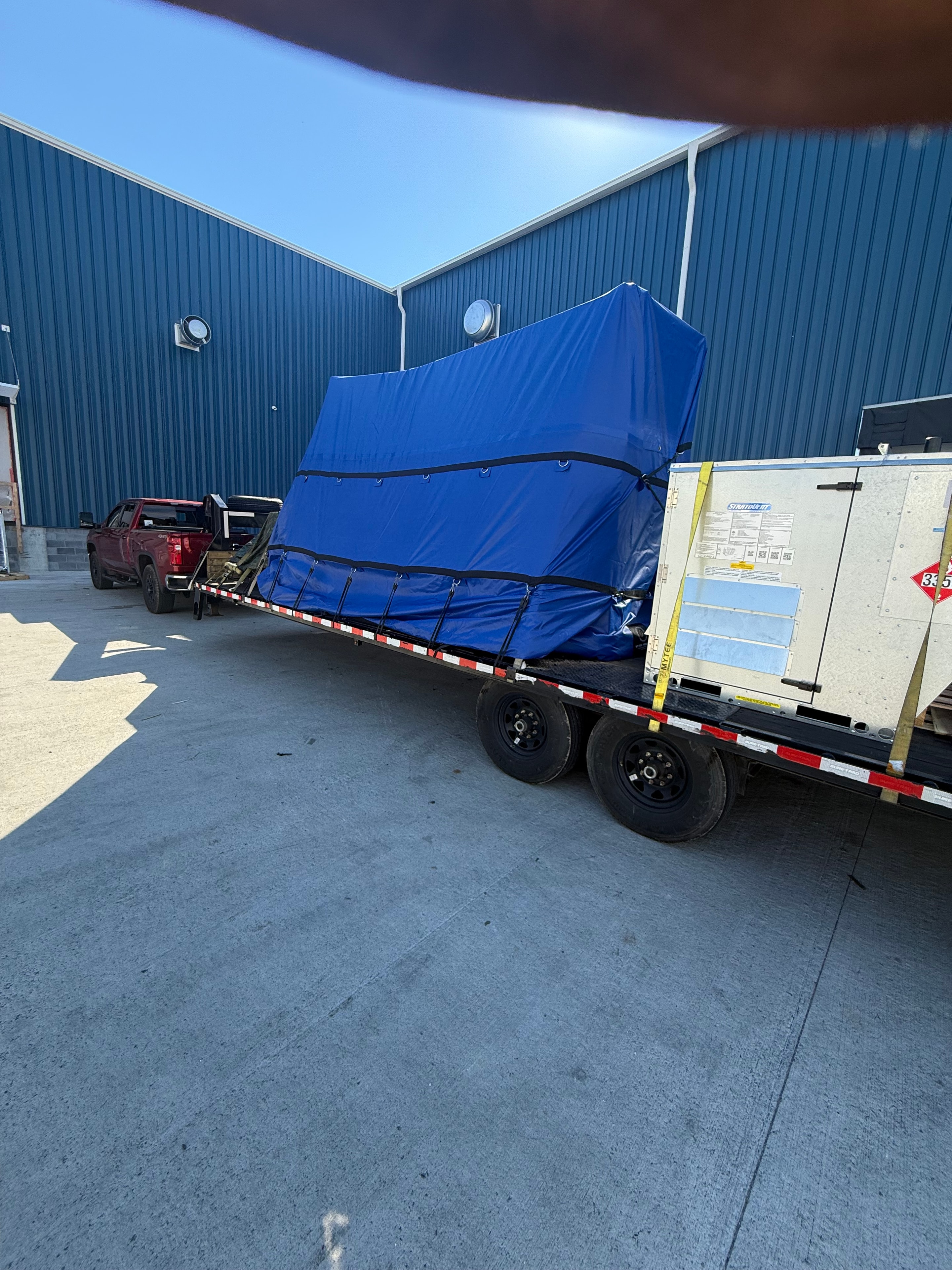 Blue tarp covered load on flatbed trailer